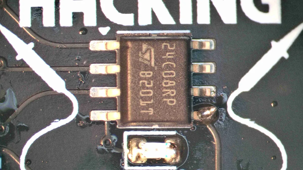 The chip held by its bottom-right leg, all eight legs lined up on their pads